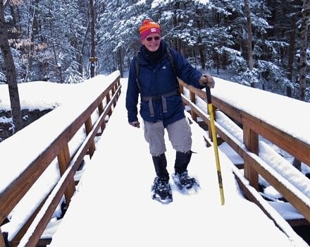 A happy hiker snowshoes on the Harris Center's Eastview Trail in Harrisville, NH. (photo © Meade Cadot)