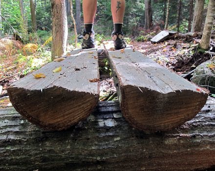 A pair of feet on a wooden footbridge. (photo © Brett Amy Thelen)