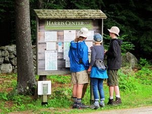 A family looks at trail maps at a Harris Center kiosk. (photo © Brett Amy Thelen)