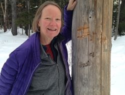 Janet Altobello stands next to a bear-bitten telephone pole.