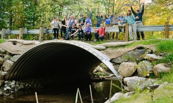 AFTER: A team of volunteers celebrates a successful restoration project. The new open-bottom arch crossing allows the brook to flow unimpeded under Hale Hill Road. (photo © Emily Lord/Nature Groupie)