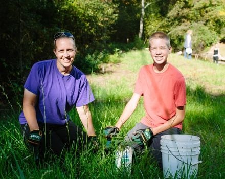 A mother-son team takes a break from planting during a volunteer workday in 2016. (photo © Emily Lord/Nature Groupie)
