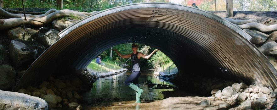 A KSC student splashes in the newly-restored stream during a volunteer workday in October 2016. (photo © Emily Lord/Nature Groupie)