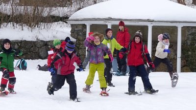 Kids enjoy a snowshoe race at the Harris Center's winter vacation camp. (photo © Caitlin Houlihan)