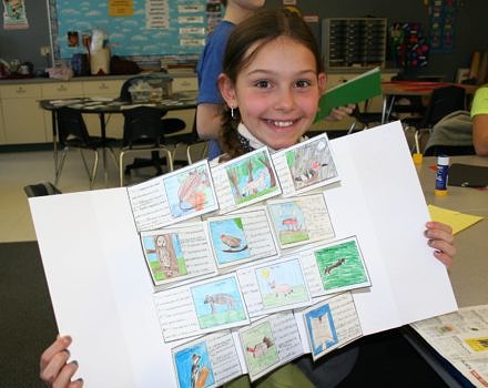 A proud Antrim Elementary School student shows off her handmade field guide to the Great Brook Woods. (photo © Jenn Sutton)