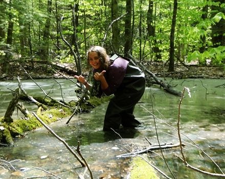 Intern Alex Kirk wades into a vernal pool in search of amphibian eggs.