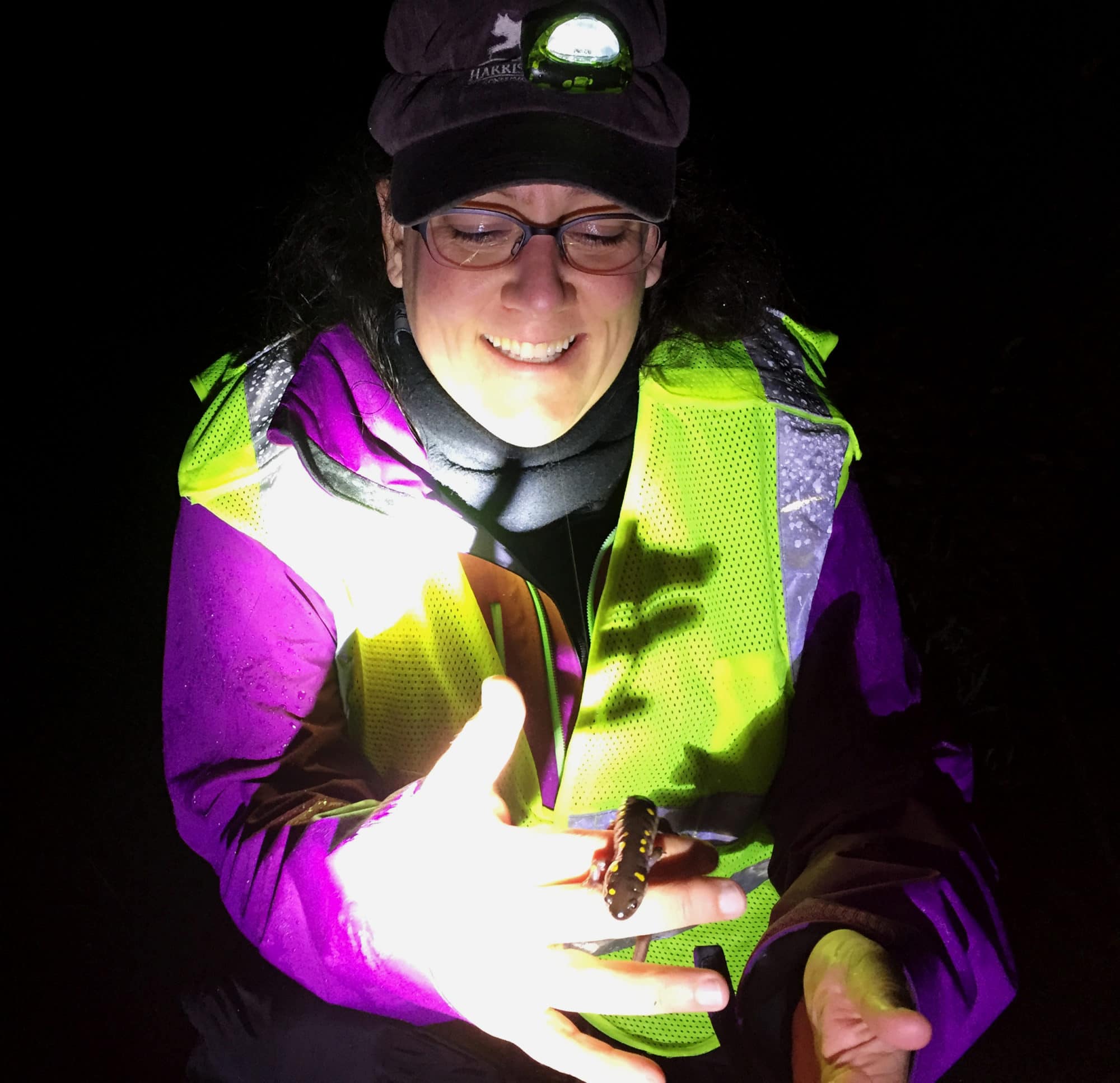 Brett Amy Thelen with a spotted salamander on Big Night. (photo © Anna Miller)