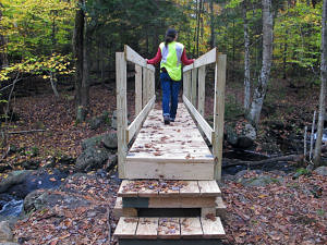 A hiker tries out the new footbridge over Bailey Brook. (photo © Russ Cobb)