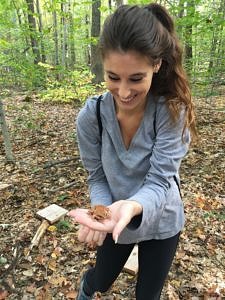 Ashley Ronzio smiles at a wood frog....and it smiles back.