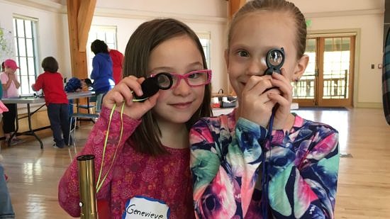 Two elementary school students peer through hand lenses. (photo © Margaret Baker)