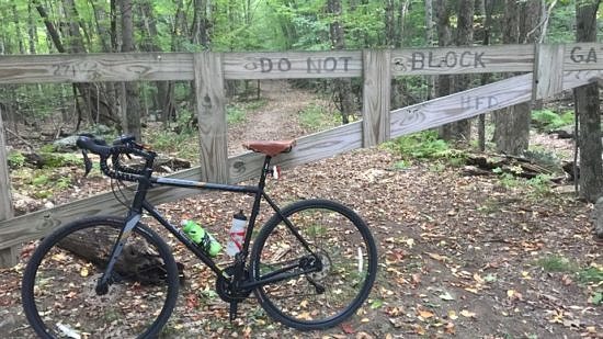 A bicycle rests at the gate to the Harris Center's Cadot Trail. (photo © Russ Cobb)