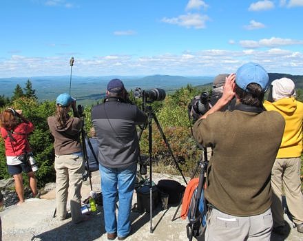 People peer through binoculars at the Pack Monadnock Raptor Observatory. (photo © Brett Amy Thelen)
