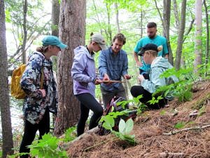 Jeremy Wilson trains a team of Keene State College interns on how to sample and preserve tree cores for a dendrochronology study of Norway Pond. (photo © Brett Amy Thelen)