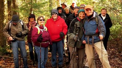 A group of happy hikers pauses in the woods. (photo © Meade Cadot)