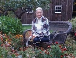 Lisa Murray sits among her flower beds.