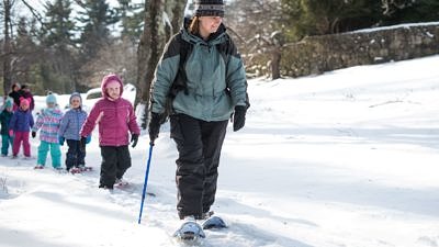 Harris Center naturalist Jaime Hutchinson leads a winter tracking expedition on the Harris Center grounds. (photo © Ben Conant)