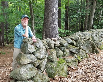 Meade Cadot smiles as he leans on one of the Harris Center's many stone walls.