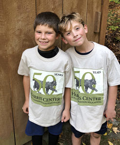 A photo of two boys wearing Harris Center 50th Anniversary commemorative t-shirts.