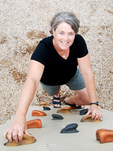 A photo of Beth Corwin on a climbing wall.