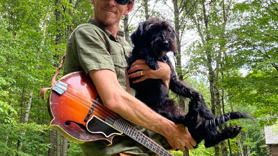 Harris Center naturalist John Benjamin with his mandolin and canine companion Griffin.