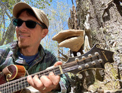 Harris Center naturalists performs a mandolin duet with a shelf fungus.