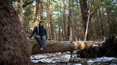Harris Center naturalist John Benjamin sits on a large fallen tree. (photo © Ben Conant)