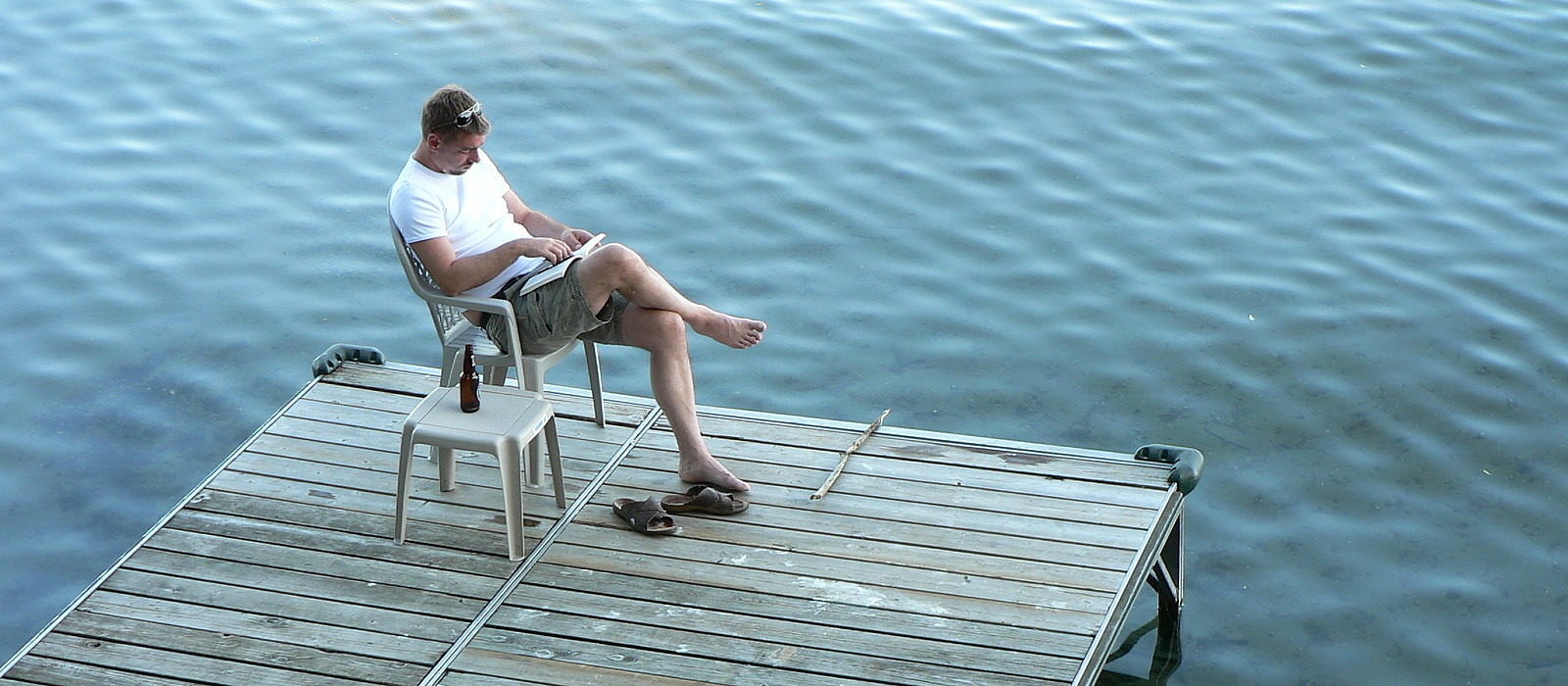 A man kicks back dockside with a good book. (photo © Ryk Venema via the Flickr Creative Commons)
