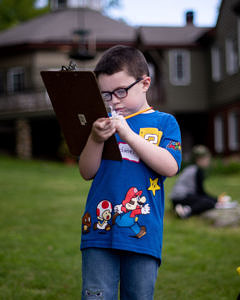 A boy stands outside with a clipboard. (photo © Ben Conant)