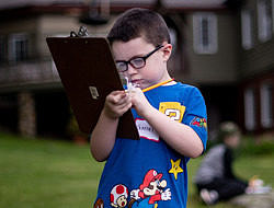 A boy uses a clipboard to record observations outside. (photo © Ben Conant)