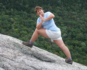 Mer Wyzga strikes a yoga pose on the side of a mountain.