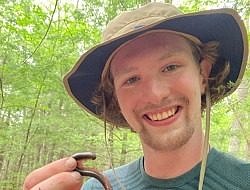 Walter Horgan smiles while holding a millipede.