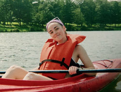 Zoe Dreyfus paddles in a red kayak.