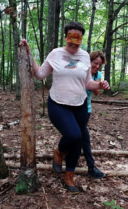 A teacher leads another teacher, blindfolded, through the woods. (photo © Claudia Dery)