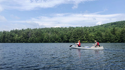Two people paddle a canoe on Spoonwood Pond. (photo © Brett Amy Thelen)