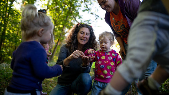 Naturalist Susie Spikol shares a wild find with toddlers, babies, and their parents during a Babies in Backpacks program. (photo © Ben Conant)