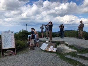 Visitors and biologists look for hawks from the Pack Monadnock Raptor Observatory platform on September 6, 2021. (photo © Phil Brown)