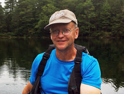 Eric Swope, paddling a canoe on a wilderness pond.