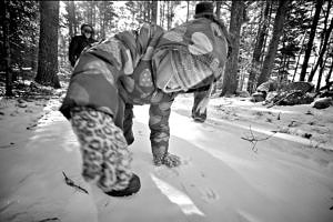 A toddler walks like a deer on a snowy morning in the woods. (photo © Bill Gnade)