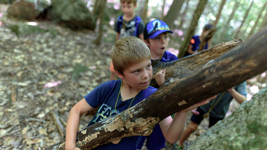 A group of boys works together to build a fort in the woods. (photo © Ben Conant)