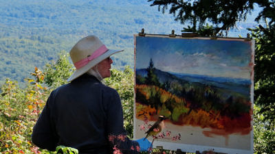 An artist paints "en plein air" while a Cedar Waxwing watches from a nearby perch. (photo © Meade Cadot)