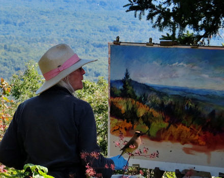 An artist paints "en plein air" while a Cedar Waxwing watches from a nearby perch. (photo © Meade Cadot)