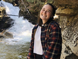 Jessica Lawton smiles in front of a waterfall.