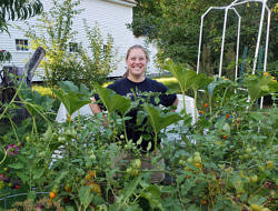 Kara Reynolds standing in a lush vegetable garden.