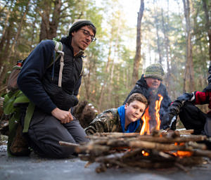 Harris Center naturalist John Benjamin gathers with students in the Harris Center's afterschool "Yeti Club" to practice fire building. (photo © Ben Conant)
