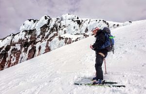 Brian Hutchings, standing on skis on a snowy slope in backcountry skiing gear.