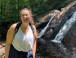 Jessica Lawton smiles in front of a waterfall.
