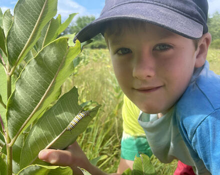 Alden Brown up close with a milkweed plant (photo: Susie Spikol)