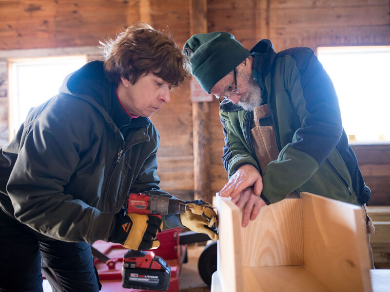 Two volunteers work together to build a kestrel nest box. (photo © Ben Conant)