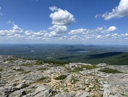 The view from Mount Monadnock's summit, on a day with white, puffy clouds hanging in a blue sky. (photo © Audrey Dunn)