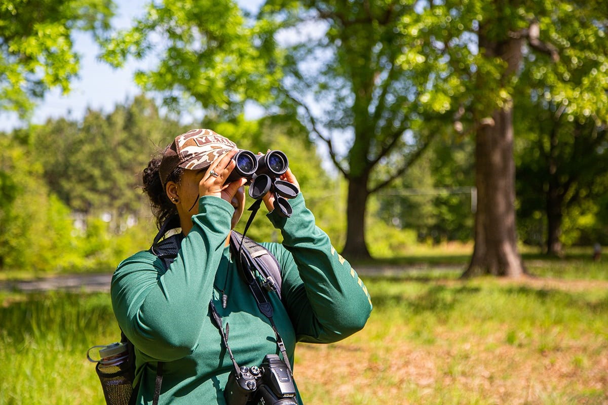 Lauren Pharr uses binoculars in the field. (photo © Chuck Gordon)